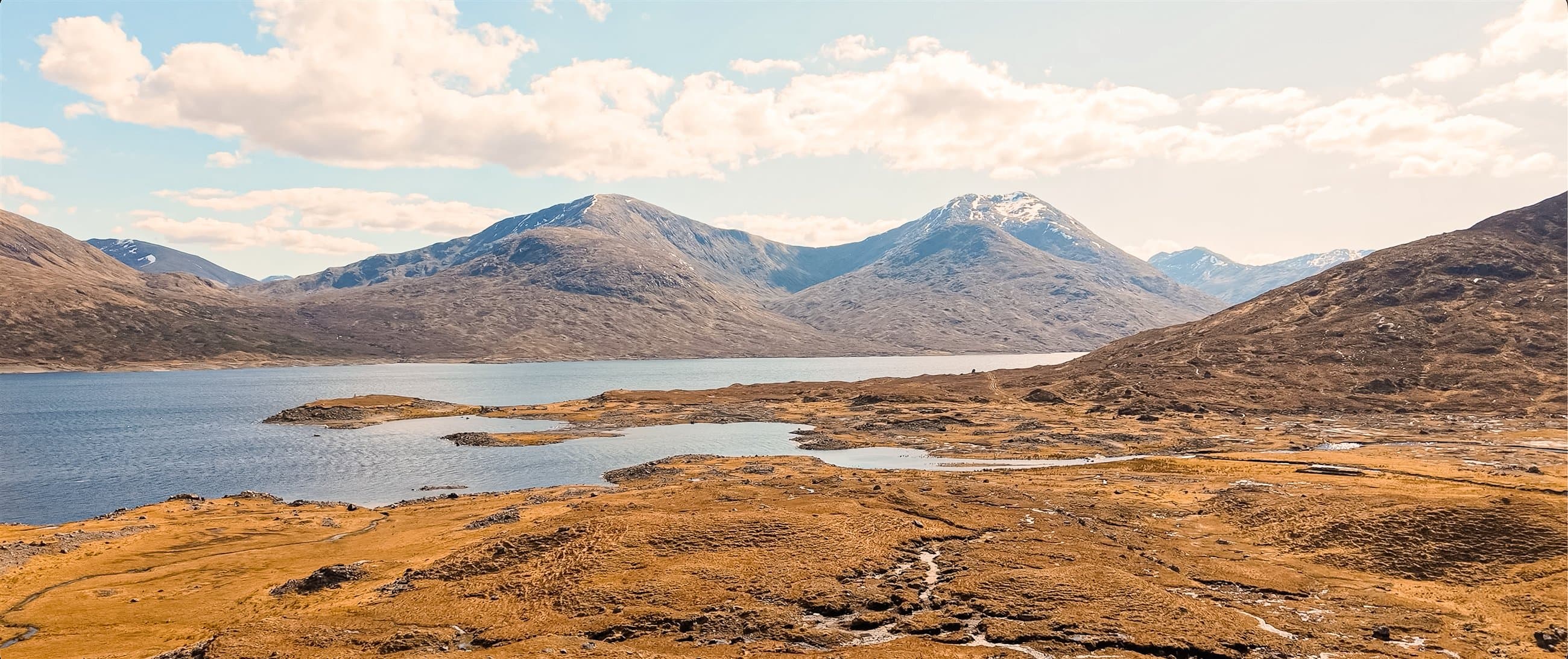 Wide view across a Highland loch and mountain range
